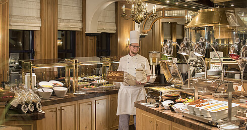 Frühstücksbuffet im Restaurant "Rôtisserie" im Maritim Hotel Bonn mit einer Auswahl an Speisen und einem freundlichen Koch.