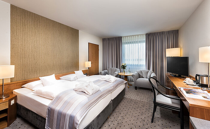 Superior Doppelzimmer mit Kingsize-Bett, Bademänteln, Sitzbereich und Schreibtisch im Maritim Hotel Hannover.