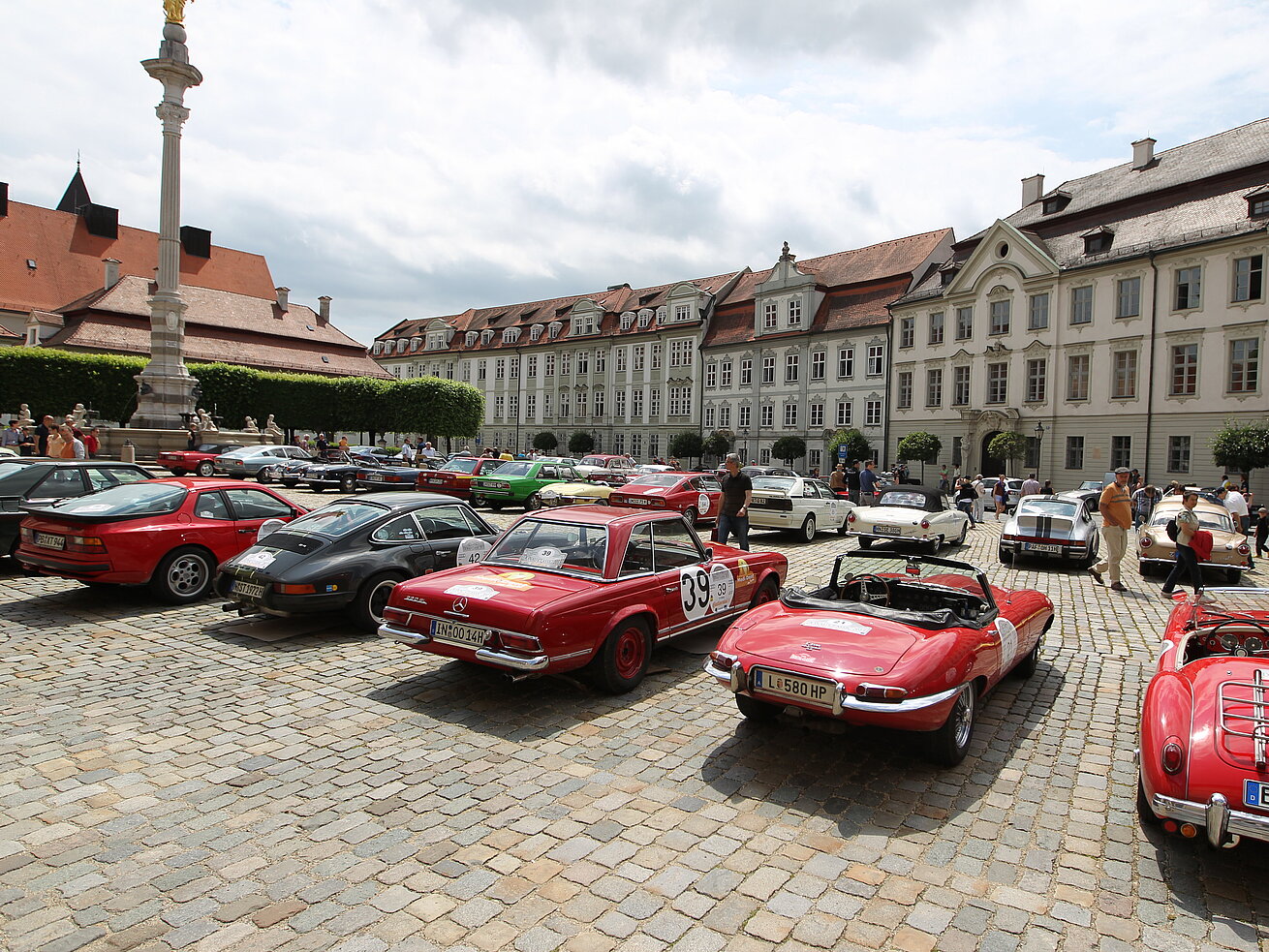 Oldtimer-Treffen mit klassischen Fahrzeugen auf einem historischen Platz vor barocker Kulisse