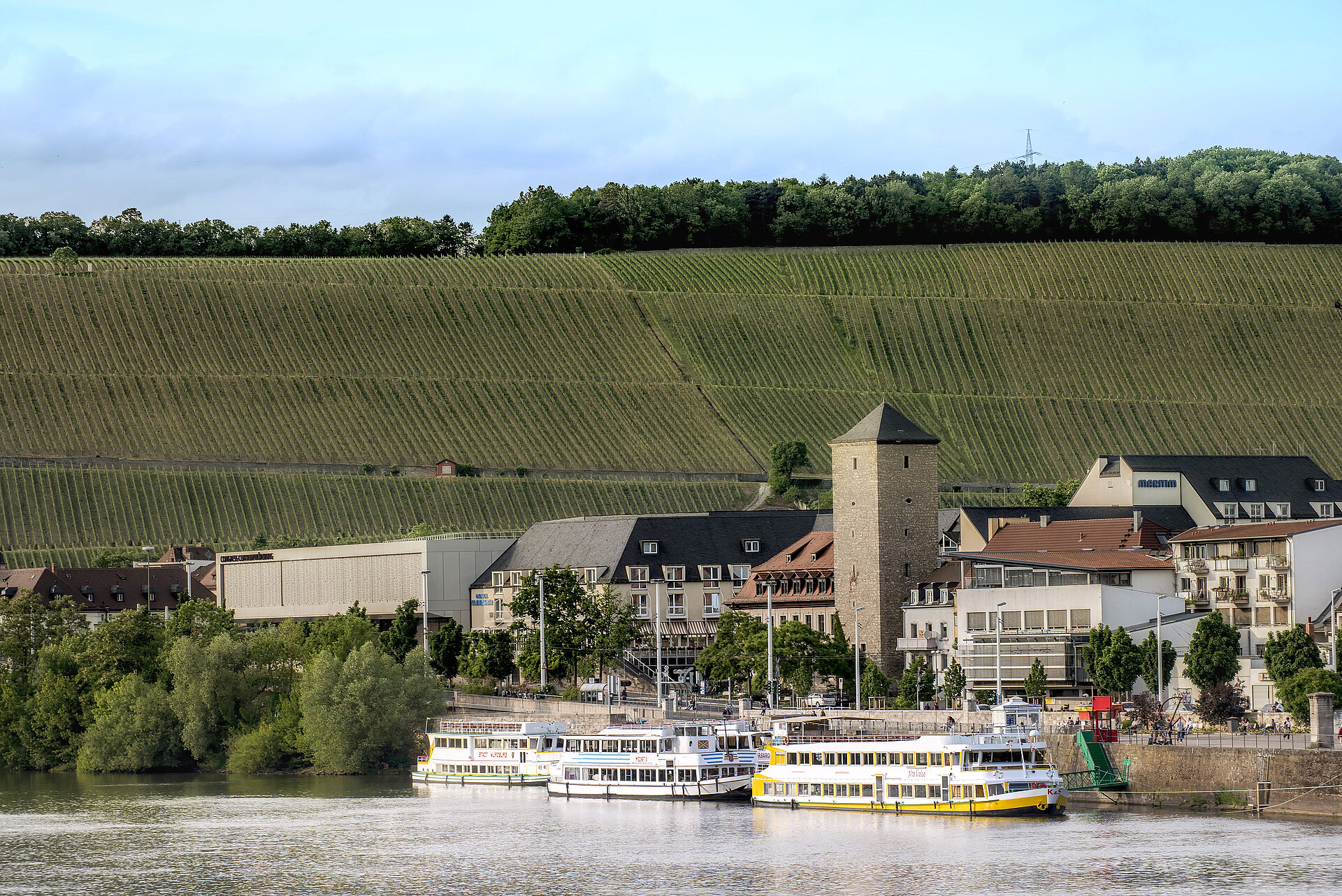 Außenansicht Maritim Hotel Würzburg und Congress Centrum mit Blick auf Weinberge und Anlegestelle am Main