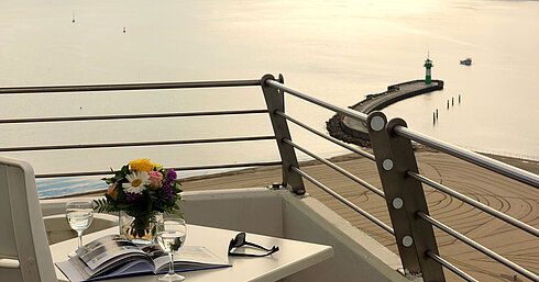 Balkon mit Meerblick im Maritim Hotel Travemünde, gedeckter Tisch mit Wein und Blumen