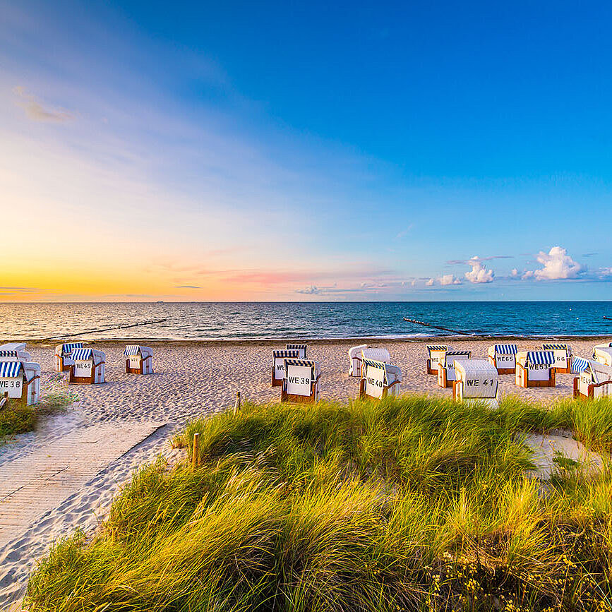 © powell83 - AdobeStock.com Strand mit Strandkörben und Dünen an der Ostsee bei Sonnenuntergang