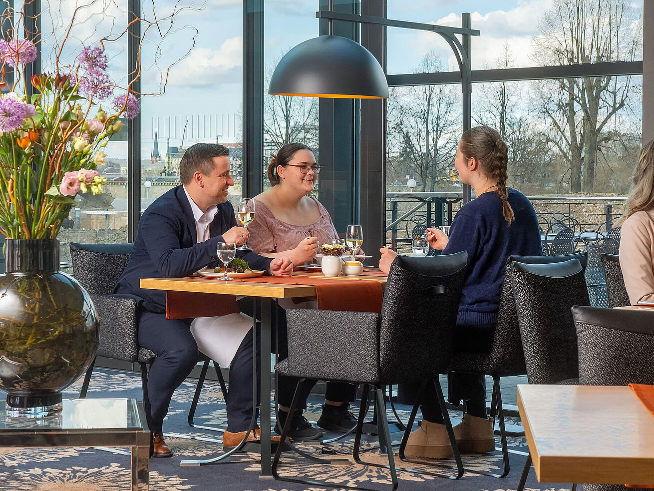 Gäste genießen Speisen im Restaurant des Maritim Hotel Dresden mit Blick nach draußen.