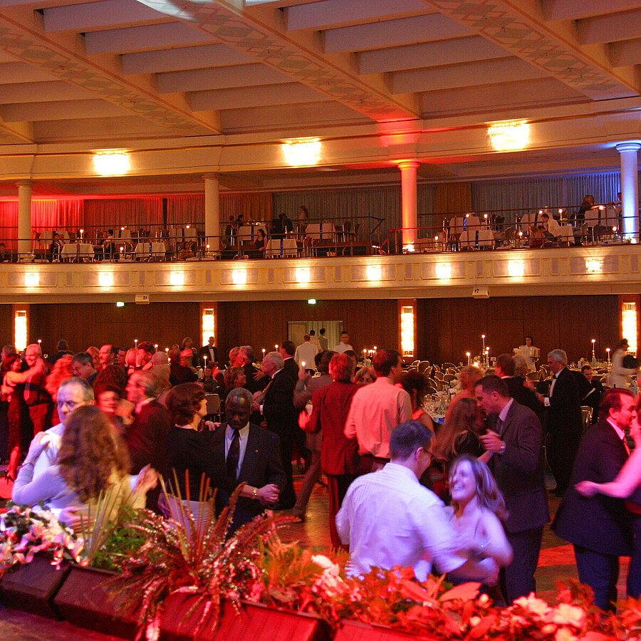 Veranstaltung im großen Saal des Maritim Hotels Bonn mit tanzenden Gästen, beleuchtetem Saal und gefüllten Emporen.