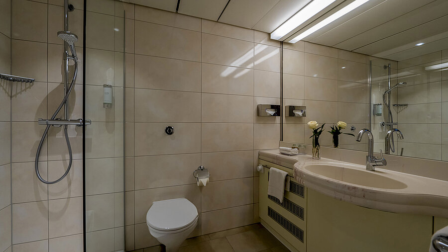 Modernes Badezimmer mit Dusche, Doppelwaschbecken und großer Spiegelwand, elegant und funktional gestaltet