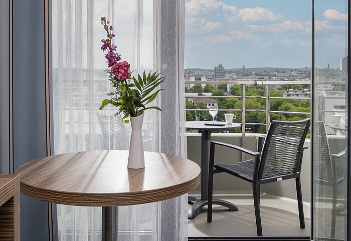 Blick vom Superior Zimmer auf den möblierten Balkon mit weitem Ausblick über die Stadt Darmstadt