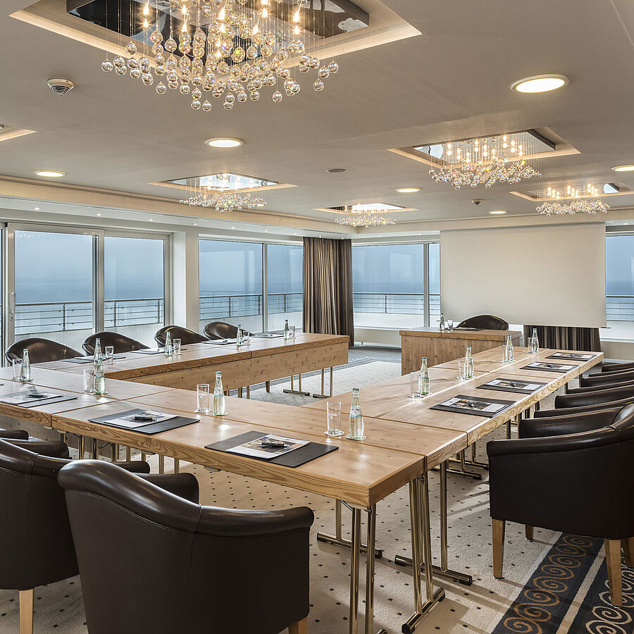 Seminar mit Meerblick Salon Hamburg im Maritim Seehotel Timmendorfer Strand, Tagungsraum mit Meerblick, L-förmiger Tisch und eleganter Beleuchtung.
