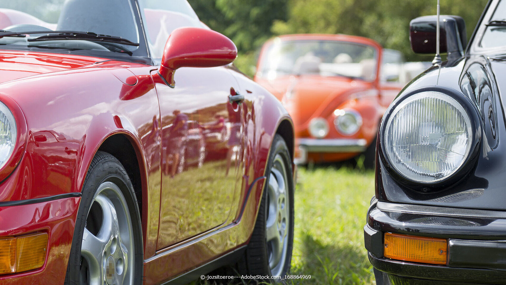 Klassische Oldtimer-Sportwagen nebeneinander auf einer Wiese bei einem Oldtimer-Treffen