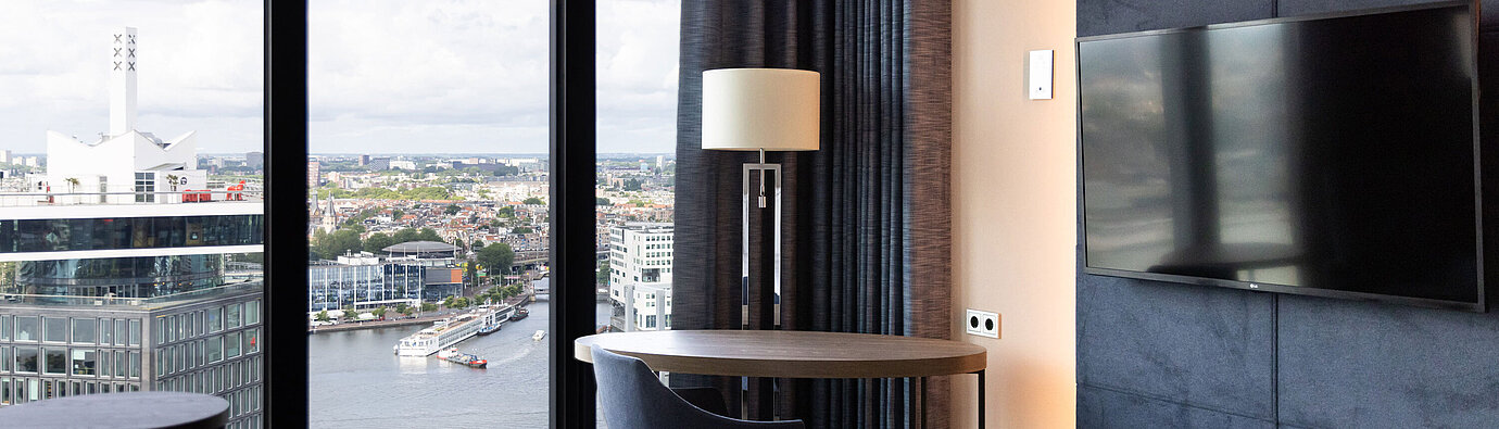 Sitzbereich mit Tisch und Ausblick auf Amsterdam im Maritim Hotel Amsterdam