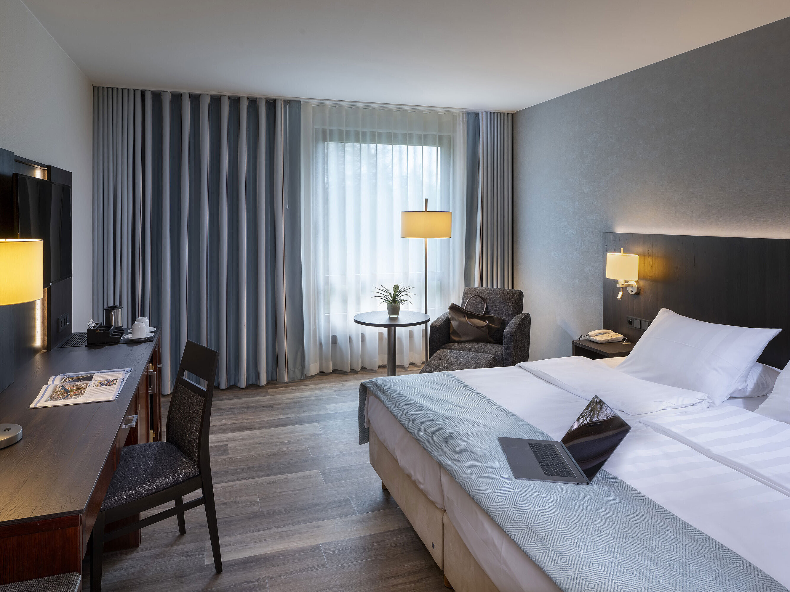 Helles Einzelzimmer im Maritim Hotel Bremen mit stilvollem Schreibtisch, komfortabler Sitzecke und großem Doppelbett.