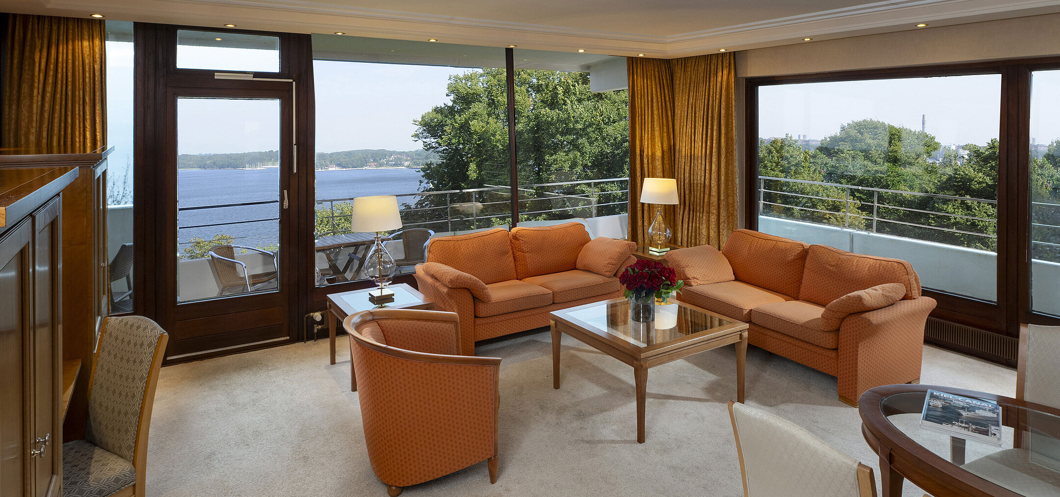Heller Wohnbereich der Präsidentensuite im Maritim Hotel Kiel mit Panoramablick auf die Ostsee und stilvollen Möbeln.
