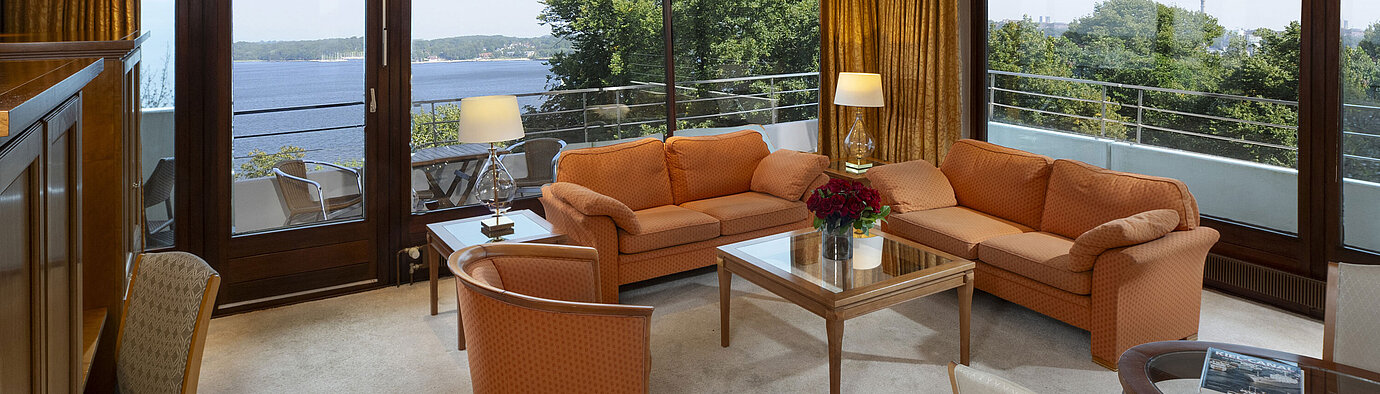 Präsidentensuite Heller Wohnbereich der Präsidentensuite im Maritim Hotel Kiel mit Panoramablick auf die Ostsee und stilvollen Möbeln.