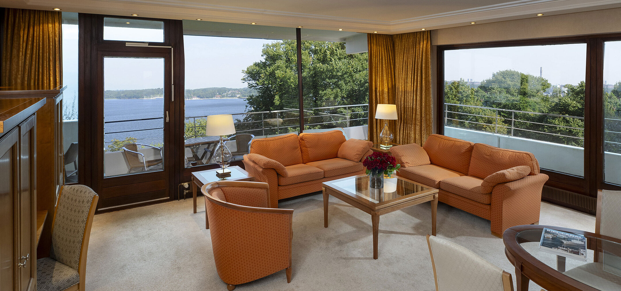 Heller Wohnbereich der Präsidentensuite im Maritim Hotel Kiel mit Panoramablick auf die Ostsee und stilvollen Möbeln.