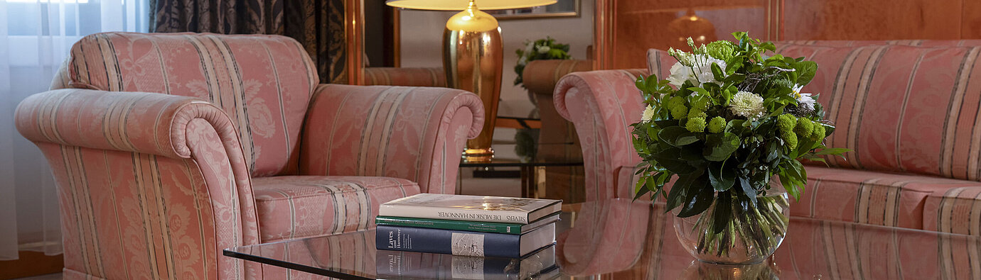 Präsidentensuite Stilvolles Wohnzimmer im Maritim Hotel Hannover mit eleganter Sitzgruppe und Glas-Couchtisch.