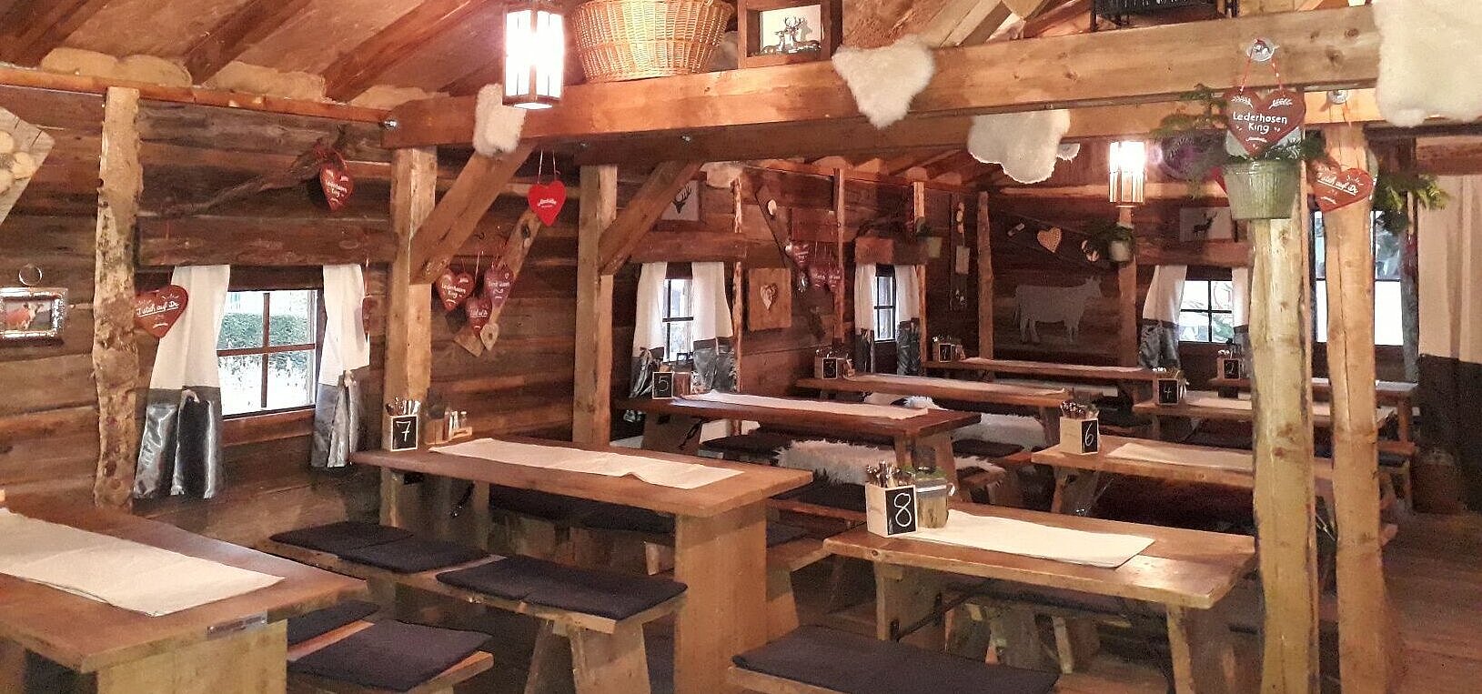 Maritim Alm (innen) Gemütlicher Gastraum mit Holztischen und Almhütten-Deko in der Maritim Alm beim Maritim Hotel Stuttgart