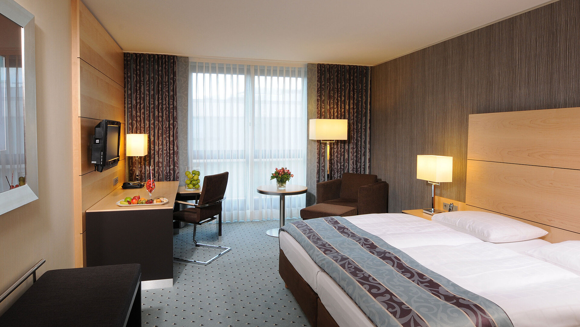 Superior Zimmer im Maritim Hotel Düsseldorf mit stilvollem Doppelbett, modernem Schreibtisch, gemütlichem Sitzbereich.