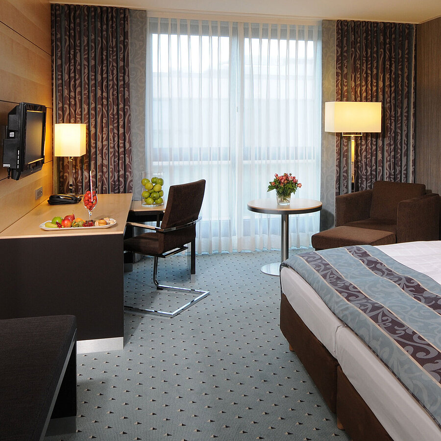 Superior Zimmer im Maritim Hotel Düsseldorf mit stilvollem Doppelbett, modernem Schreibtisch, gemütlichem Sitzbereich.