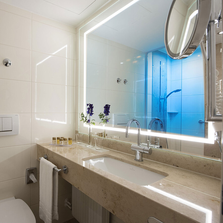 Helles Badezimmer mit großem Spiegel und Pflegeprodukten im Maritim Hotel Titisee