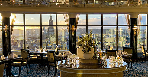 Elegantes Restaurant im Maritim Hotel Ulm mit großen Panoramafenstern und Blick über die Stadt bei Sonnenuntergang