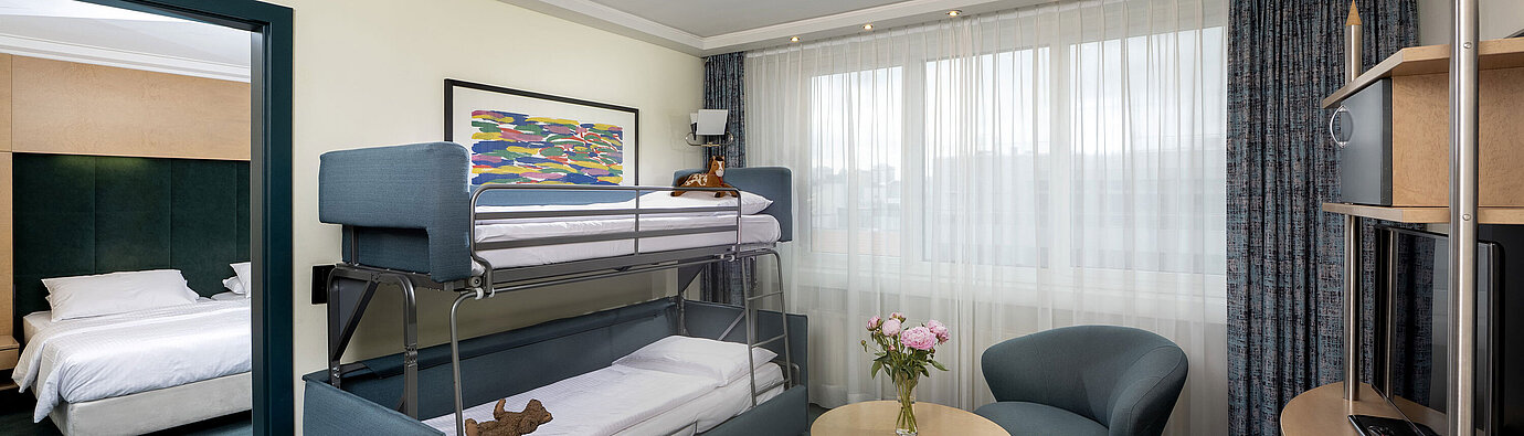 Familiensuite mit Etagenbett, Sofa, Tisch und Blick ins Schlafzimmer im Maritim proArte Hotel Berlin