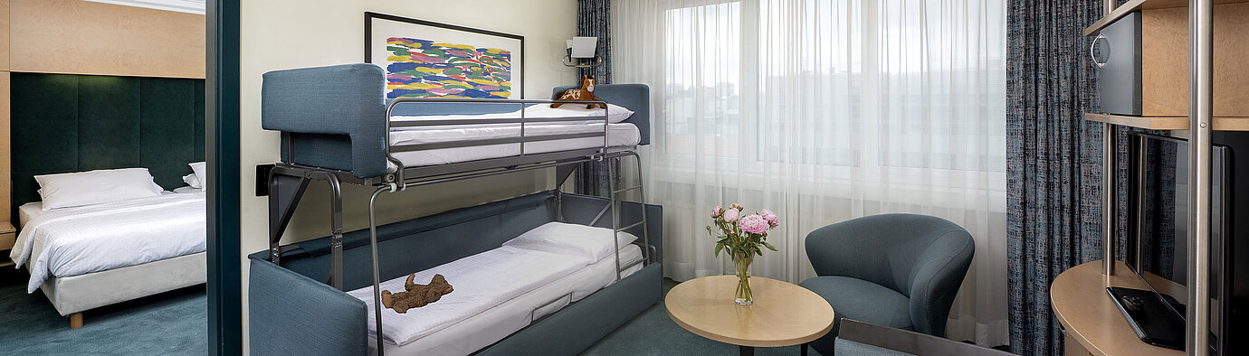 Familiensuite mit Etagenbett, Sofa, Tisch und Blick ins Schlafzimmer im Maritim proArte Hotel Berlin
