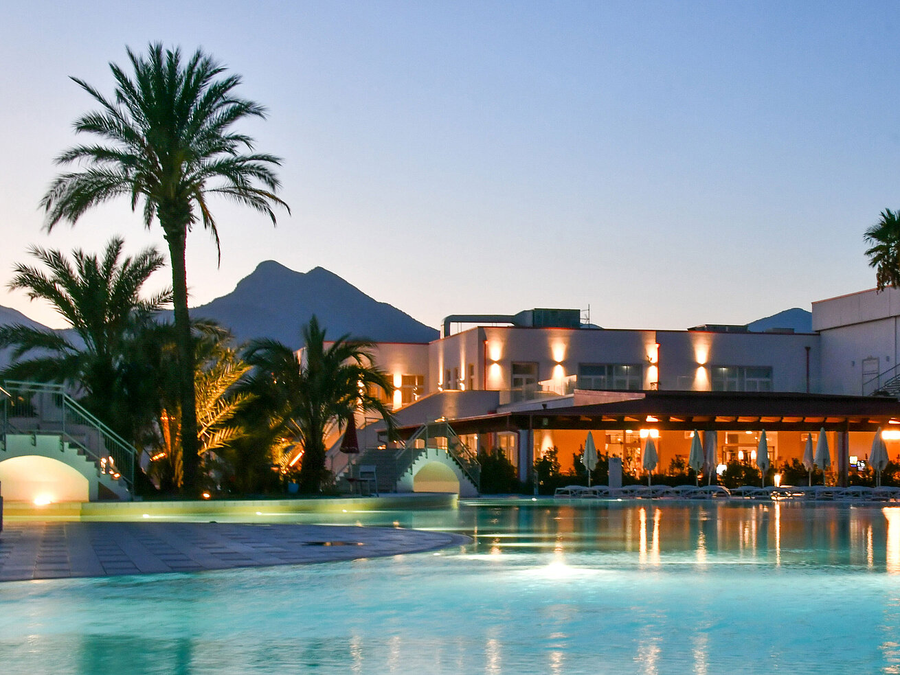 Pool Poolbeleuchtung am Abend im Maritim Resort Calabria mit Palmen und Gebirgskulisse