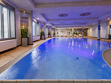 Beleuchteter Indoor-Pool im Maritim Hotel Frankfurt mit entspannter Atmosphäre und Panoramafenstern.