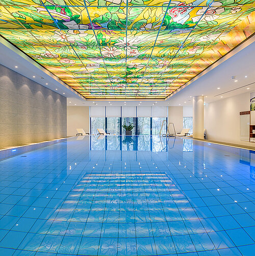 Eleganter Poolbereich im Maritim Hotel Bremen mit buntem Glasdach und moderner Beleuchtung,ideal für Wellness und Entspannung