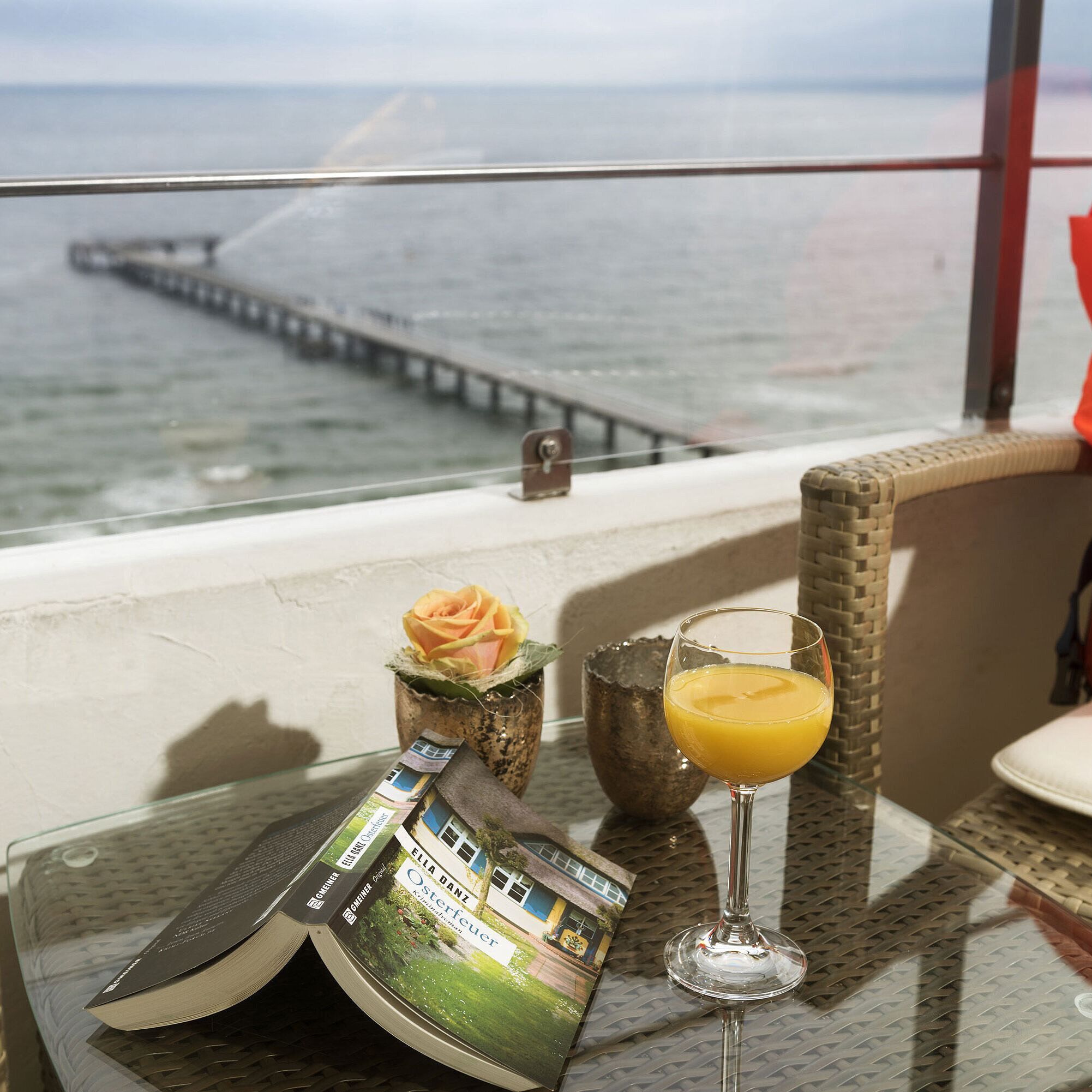 Balkon mit Meerblick, Glas Orangensaft, Buch und Rettungsweste im Maritim Seehotel Timmendorfer Strand.