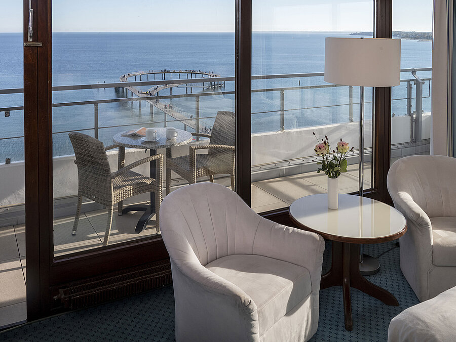 Hotelzimmer mit Sitzbereich und Balkon mit Meerblick im Maritim Seehotel Timmendorfer Strand.