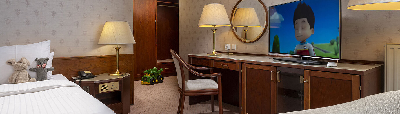 Kinderfreundliches Zimmer mit Kuscheltieren, TV mit Zeichentrickfilm und Spielzeug im Maritim Hotel Bad Wildungen