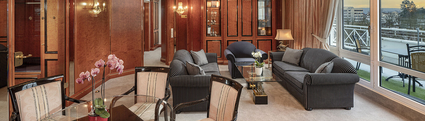 Großzügige Suite mit Kronleuchter, stilvollen Möbeln und Ausblick bei Sonnenuntergang im Maritim Hotel Bad Wildungen