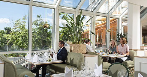 Geräumiges Restaurant im Maritim Hotel Würzburg mit Panoramafenstern und einladender Sitzgruppe