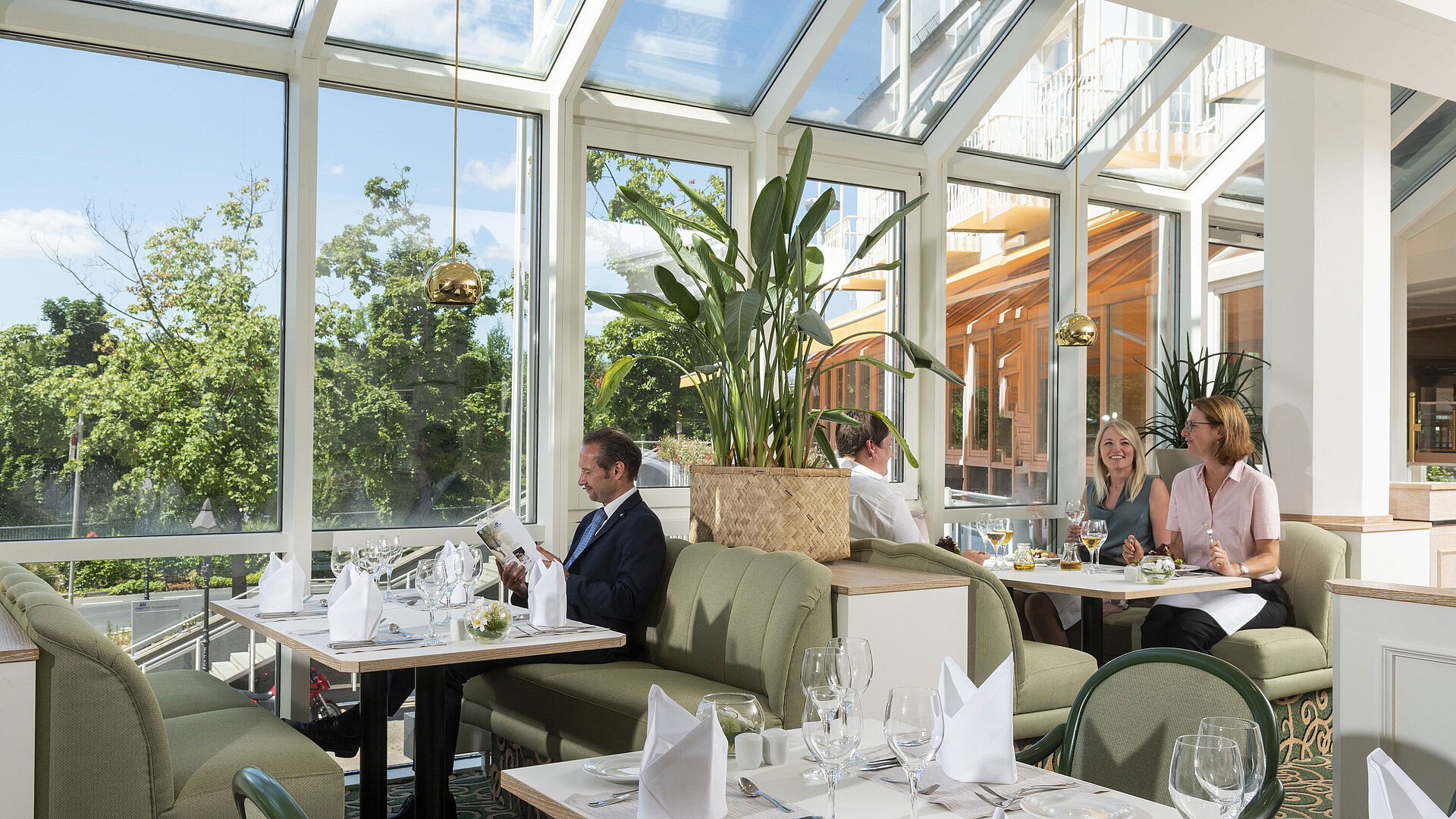 Geräumiges Restaurant im Maritim Hotel Würzburg mit Panoramafenstern und einladender Sitzgruppe