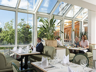Geräumiges Restaurant im Maritim Hotel Würzburg mit Panoramafenstern und einladender Sitzgruppe