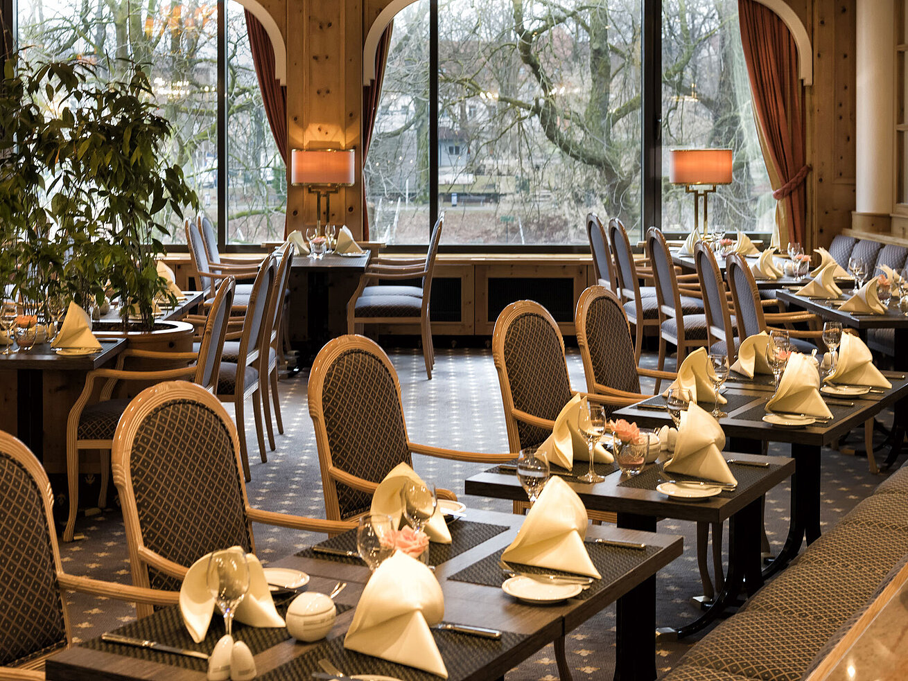 Restaurant mit Holzverkleidung und großen Fenstern im Landhausstil im Maritim Hotel Ulm