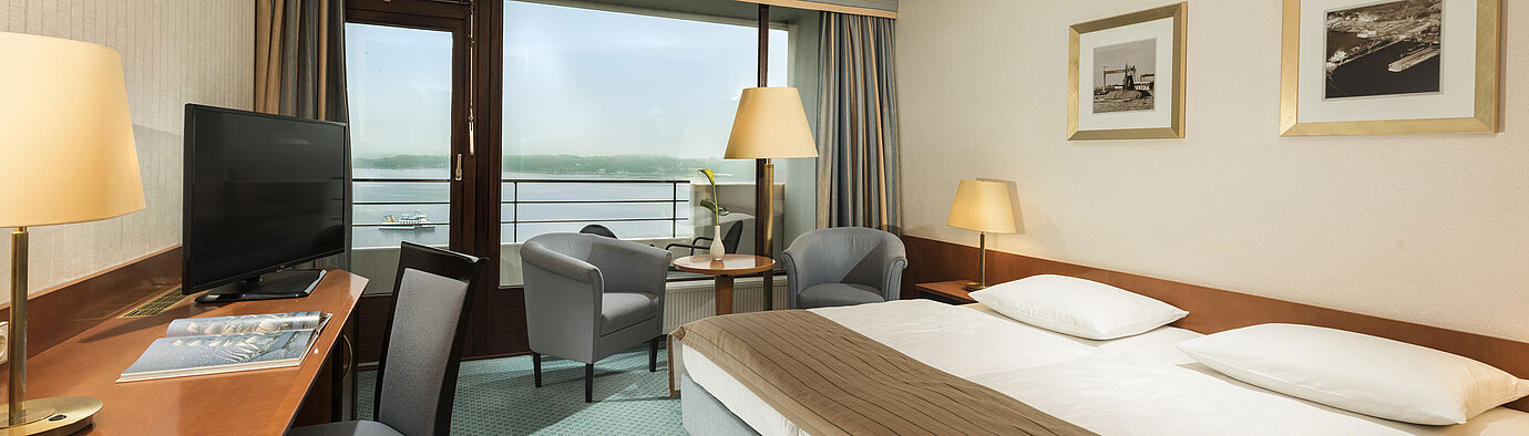 Superior Zimmer  Superior Zimmer im Maritim Hotel Kiel mit Schreibtisch, Sitzbereich, großem Doppelbett und Balkon mit Blick auf die Förde.