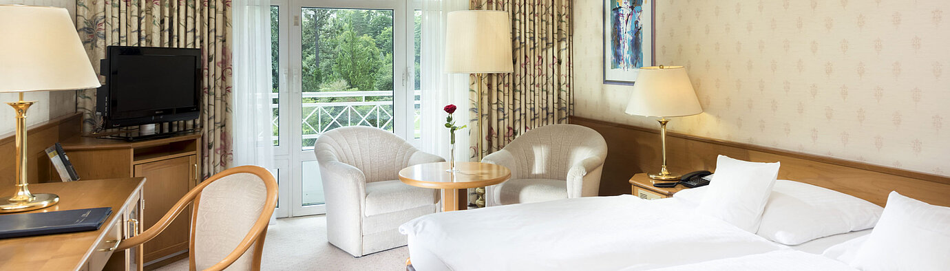 Helles Doppelzimmer mit Balkonblick und Sitzecke im Maritim Hotel Bad Wildungen