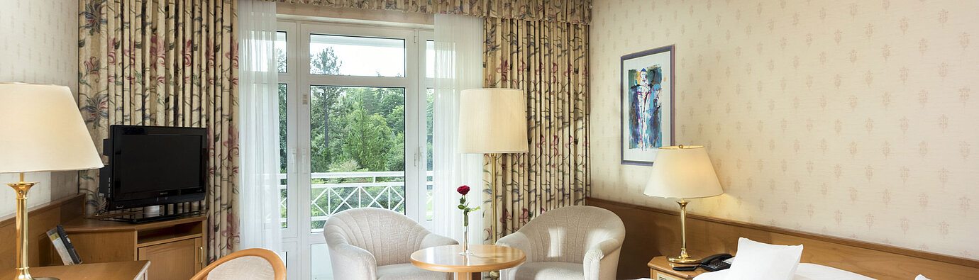 Helles Doppelzimmer mit Balkonblick und Sitzecke im Maritim Hotel Bad Wildungen