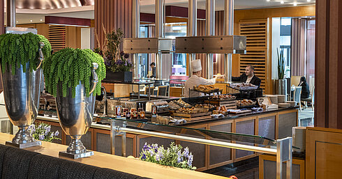  Live-Cooking-Station im Frühstücksbereich des Maritim Hotel Düsseldorf mit frischen Backwaren und eleganter Dekoration.