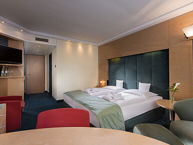 Superior-Zimmer im Maritim proArte Hotel Berlin, ausgestattet mit Doppelbett, Sitzbereich und moderner Beleuchtung.