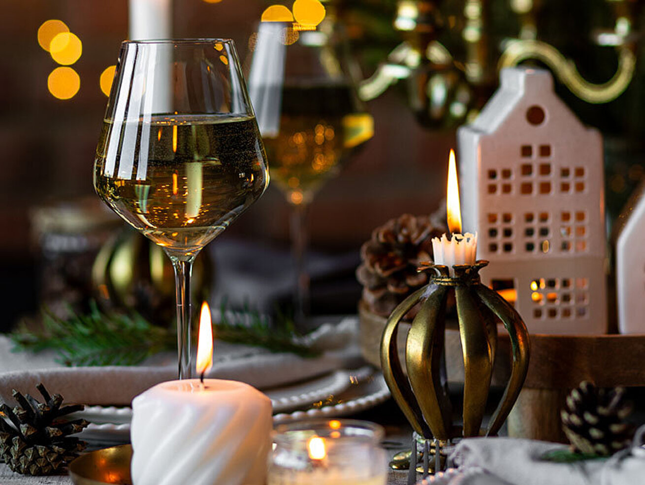 © ArtSys - AdobeStock.com Festlich gedeckter Tisch mit Kerzen, Weihnachtsdekoration und stimmungsvoller Beleuchtung