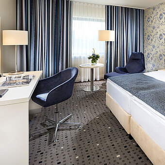 Superior Zimmer im Maritim Hotel Bonn mit modernem Design, gemütlichem Bett, Schreibtisch und stilvollen Vorhängen.