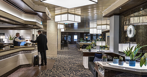 Rezeption im Maritim Hotel Darmstadt mit modernem Design, freundlichem Personal und eleganter Einrichtung.
