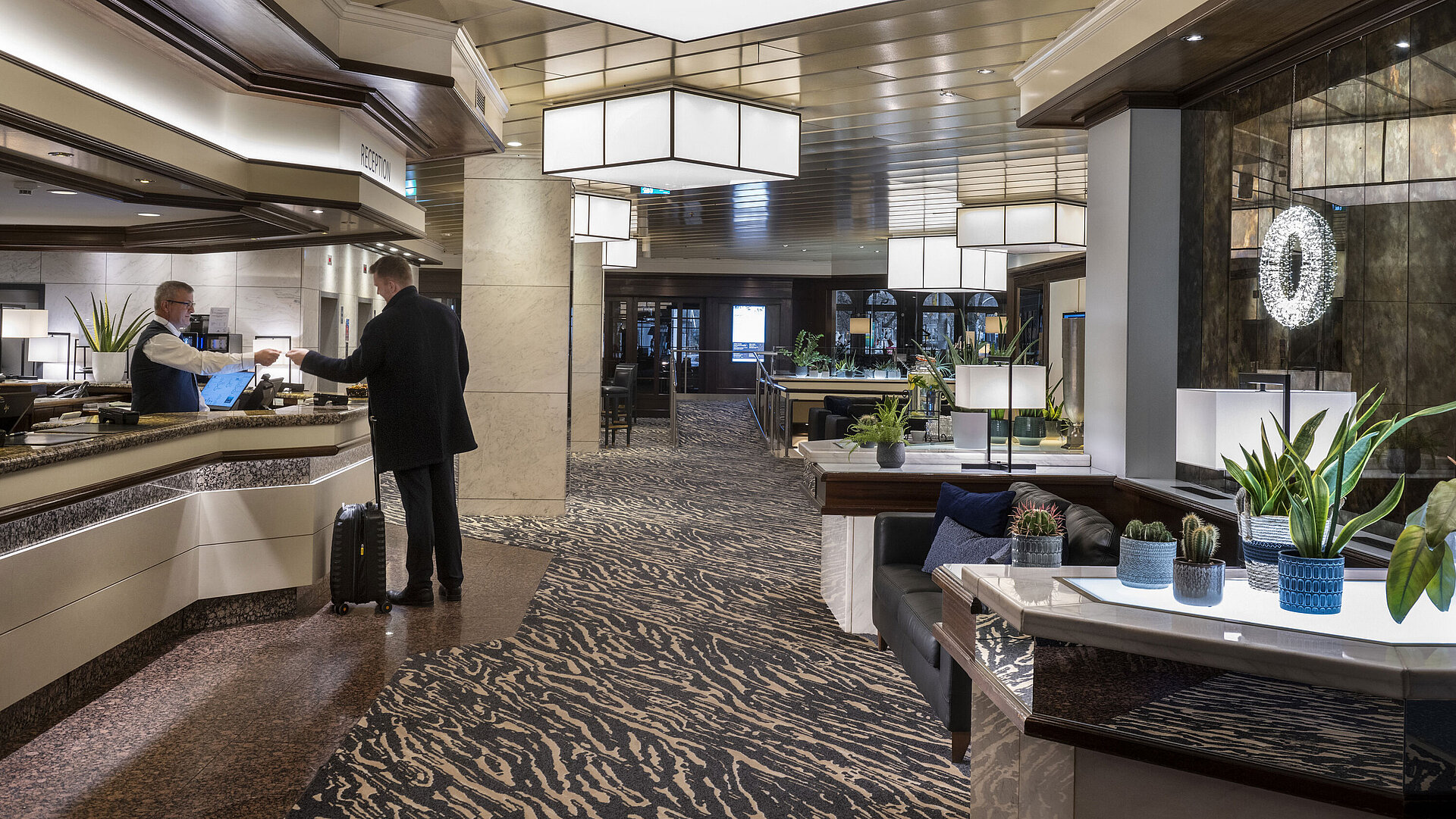 Rezeption im Maritim Hotel Darmstadt mit modernem Design, freundlichem Personal und eleganter Einrichtung.