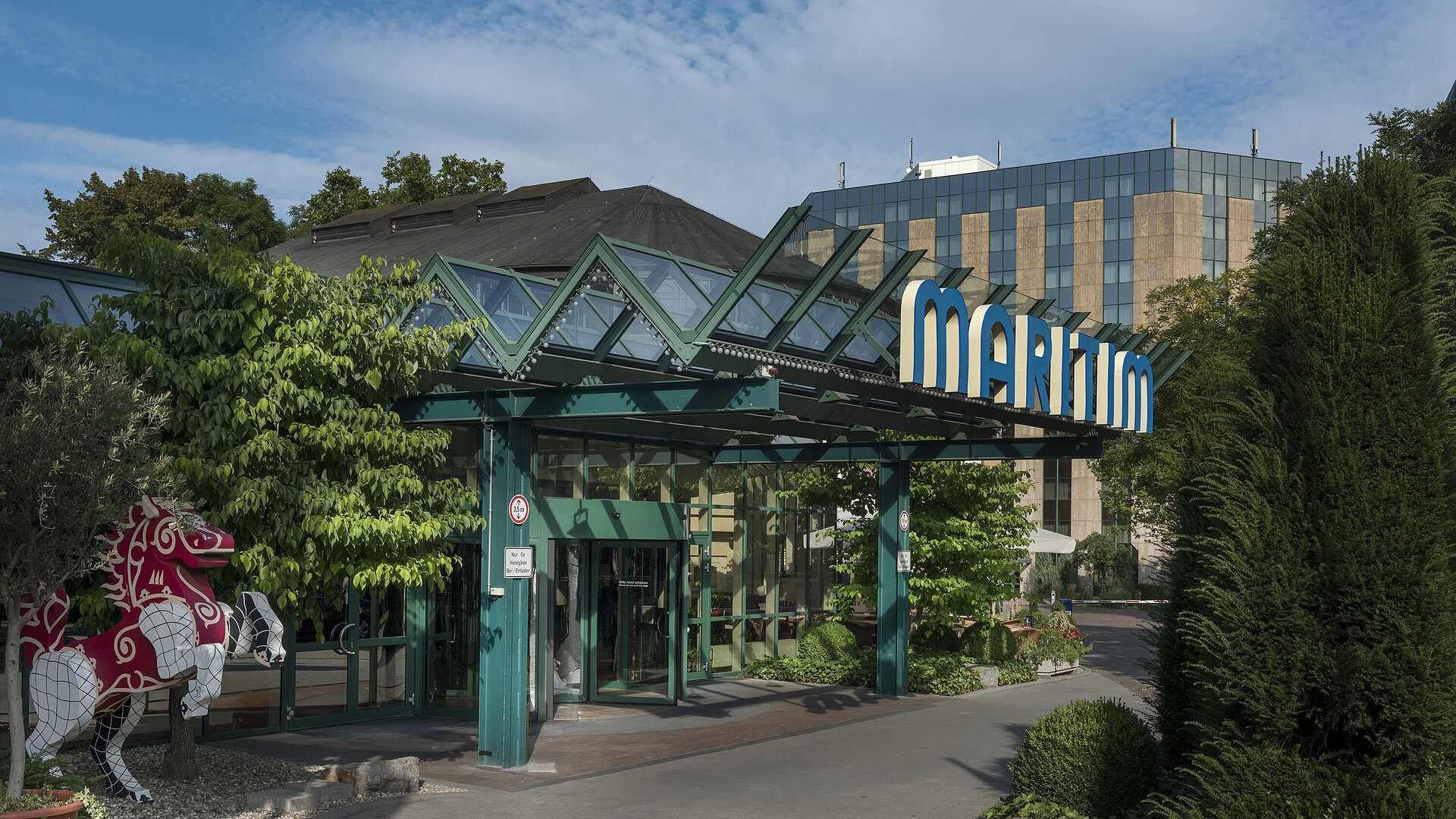 Haupteingang des Maritim Hotel Stuttgart mit Glasdach, grünem Eingangsbereich und Maritim-Schriftzug