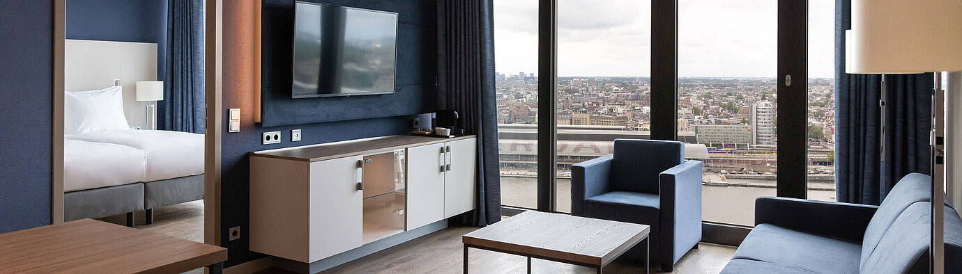 Moderner Wohnbereich mit Stadtblick und TV im Maritim Hotel Amsterdam
