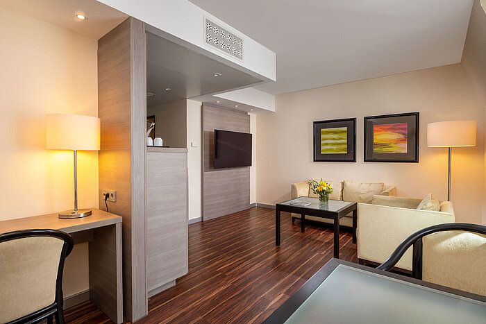 Junior Suite im Maritim Hotel Königswinter mit Wohnbereich, Sitzgruppe, Schreibtisch und offenem Raumkonzept.