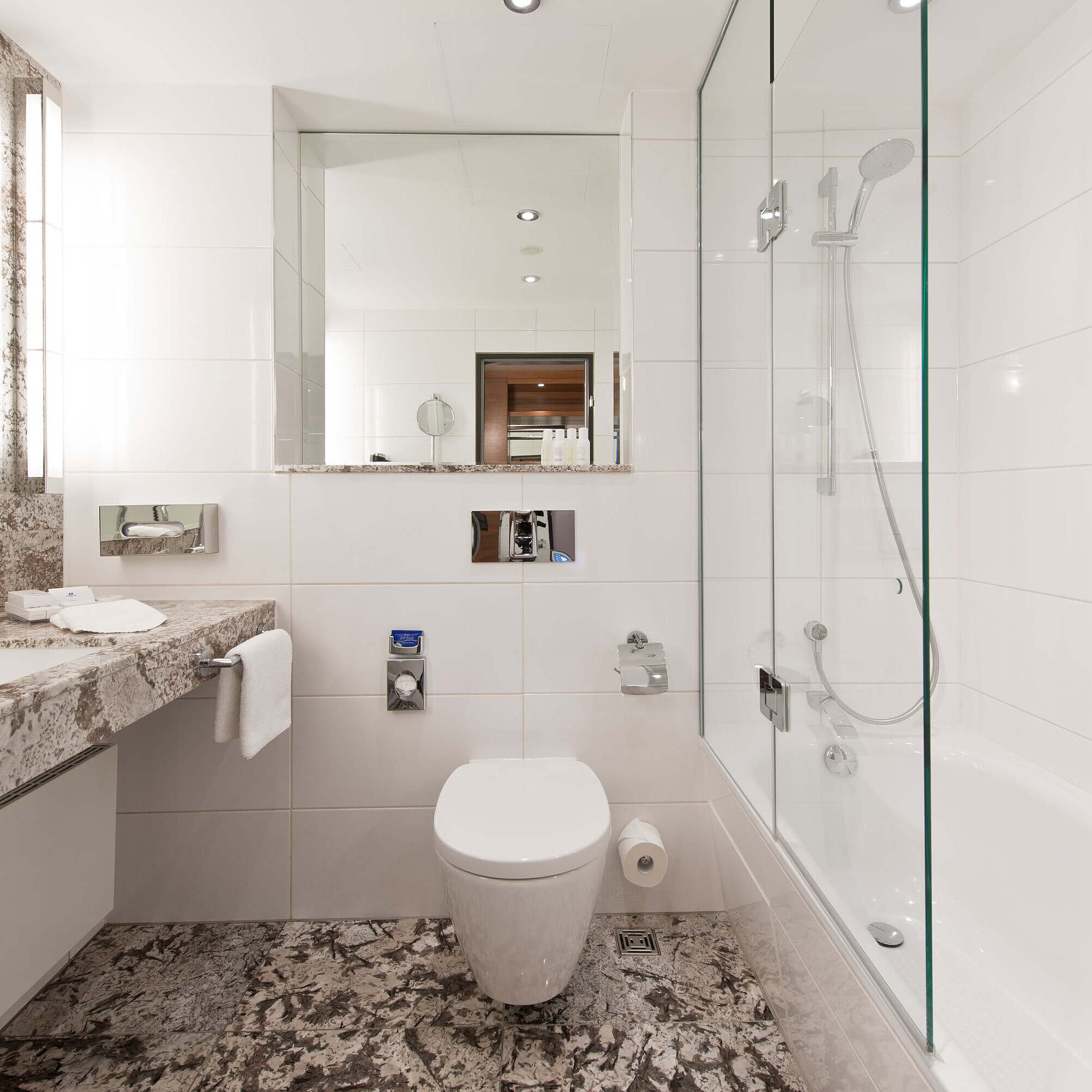Helles Badezimmer im Maritim Hotel Bad Homburg mit moderner Badewanne und eleganter Marmoreinrichtung.