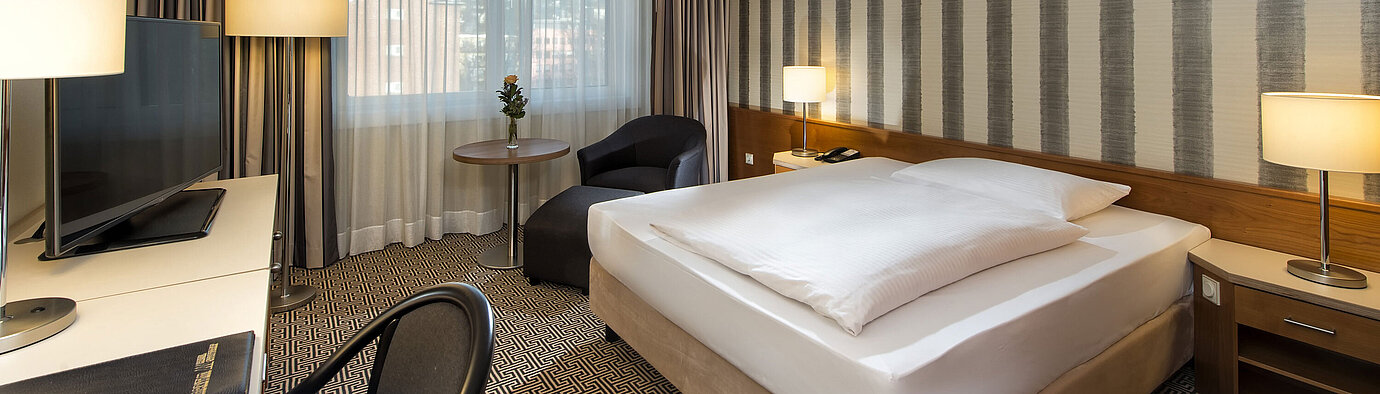Modernes Einzelzimmer mit Schreibtisch, großem Fenster und Stadtblick im Maritim Hotel Stuttgart